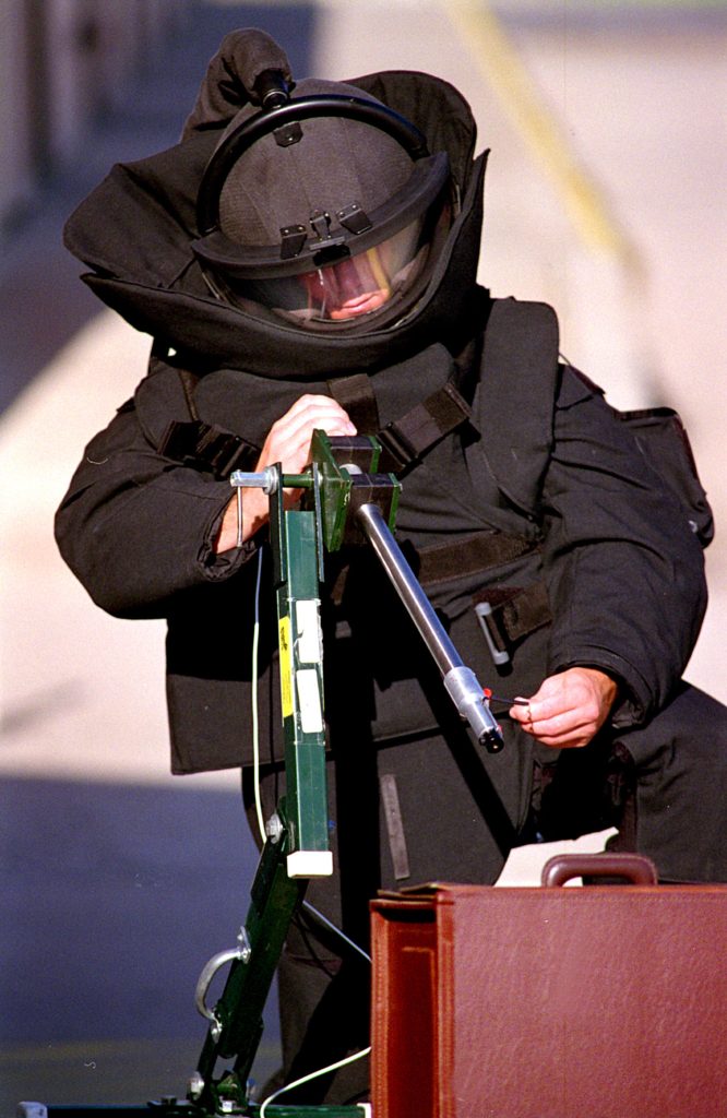 <strong>SOUND OF SILENCE</strong> — In a 2002 photo, a bomb technician aims a Percussion-Actuated Non-electric Disrupter at a mock briefcase bomb. The PAN is used by bomb squads nationwide to disable conventional, handmade bombs remotely. (Photo from the Lab News archives)