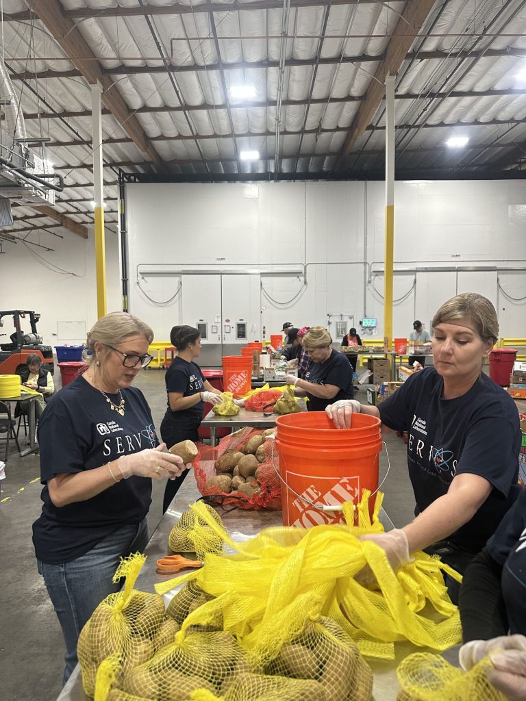 <strong>HELPING HANDS</strong> — California staff sort potatoes at Open Heart Food Bank. (Photo by Amelia Harrison)