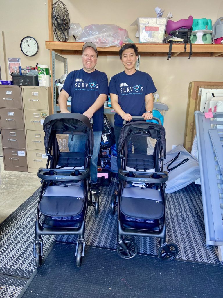 <strong>STROLLER CREW</strong> — Senior manager Jeff Gebel and manager Tommy Zhang smile with strollers they assembled at Little Miracles. (Photo by Meagan Brace)