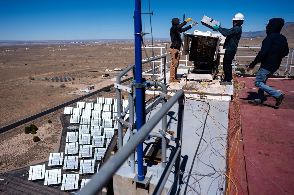 <strong>SET UP&nbsp;</strong>—&nbsp;Sandia engineers Aaron Overacker, left, Todd Arterburn, and Lockheed Martin engineer Derek Shannon, right, get ready to test heat shield material samples at the National Solar Thermal Test Facility for NASA’s Dragonfly mission to Titan.&nbsp;(Photo by Craig Fritz)