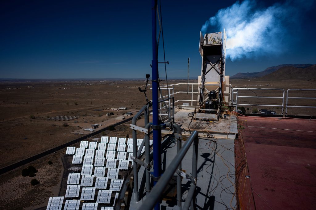 <strong>HEATING UP</strong>&nbsp;—&nbsp;Hundreds of mirrorlike heliostats concentrate sunlight on a sample of heat shield material at Sandia National Solar Thermal Test Facility. The material, developed by NASA’s Ames Research Center in California’s Silicon Valley for the Dragonfly mission, was subjected to a pulse of heat that exceeded 4,500 degrees Fahrenheit.&nbsp;(Photo by Craig Fritz)
