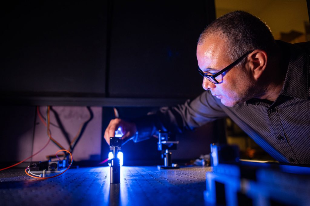 <strong>PRECISION PLACEMENT</strong> — Sandia physicist Israel Owens adjusts the optics of his laboratory system. Israel and colleagues have developed a much smaller optics system to measure how magnetic fields change the rotation of light in a rare earth crystal. (Photo by Craig Fritz)