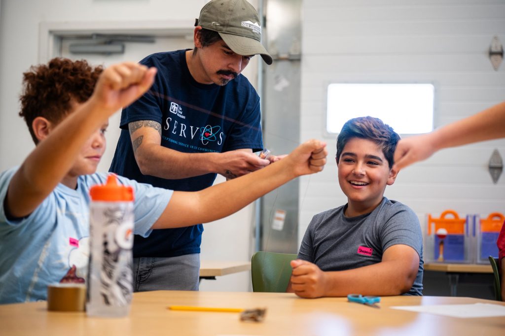 <strong>MAKING WAVES</strong> — Sandia engineer Damian Gallegos-Patterson helps Cadence Warren, left, and Beharie Shirer make a wave energy converter at Explora summer camp.