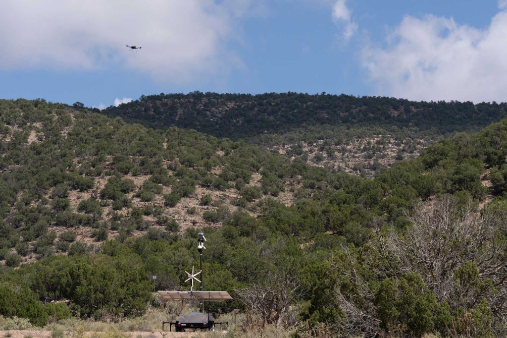 <strong>SKY HIGH </strong>— A drone flies over the Manzano Mountains, during a Sandia-led exercise. One of the objectives was to determine if a portable system, equipped with radar and high-definition cameras that can be quickly deployed to remote areas, could pick up the drone. (Photo by David Lienemann)