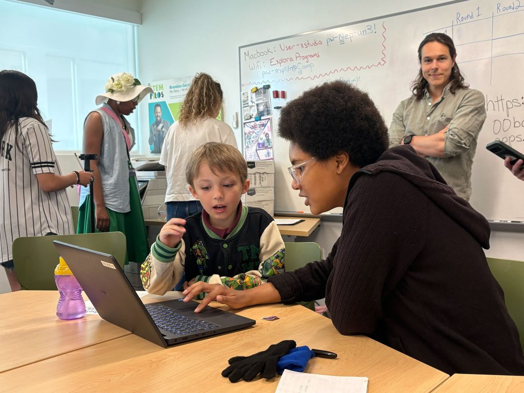<strong>ENERGY MAKERS</strong> — Explora staff walk through the virtual SIWEED game with an after-school student while wave energy technical expert Daniel Gaebele observes. (Photo by Natalie Sommer)