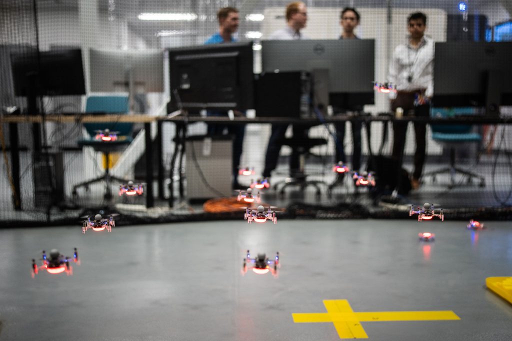 <strong>HERE WE COME</strong> — Sandia engineers and interns watch as a fleet of small, inexpensive drones take to the air for a demonstration.