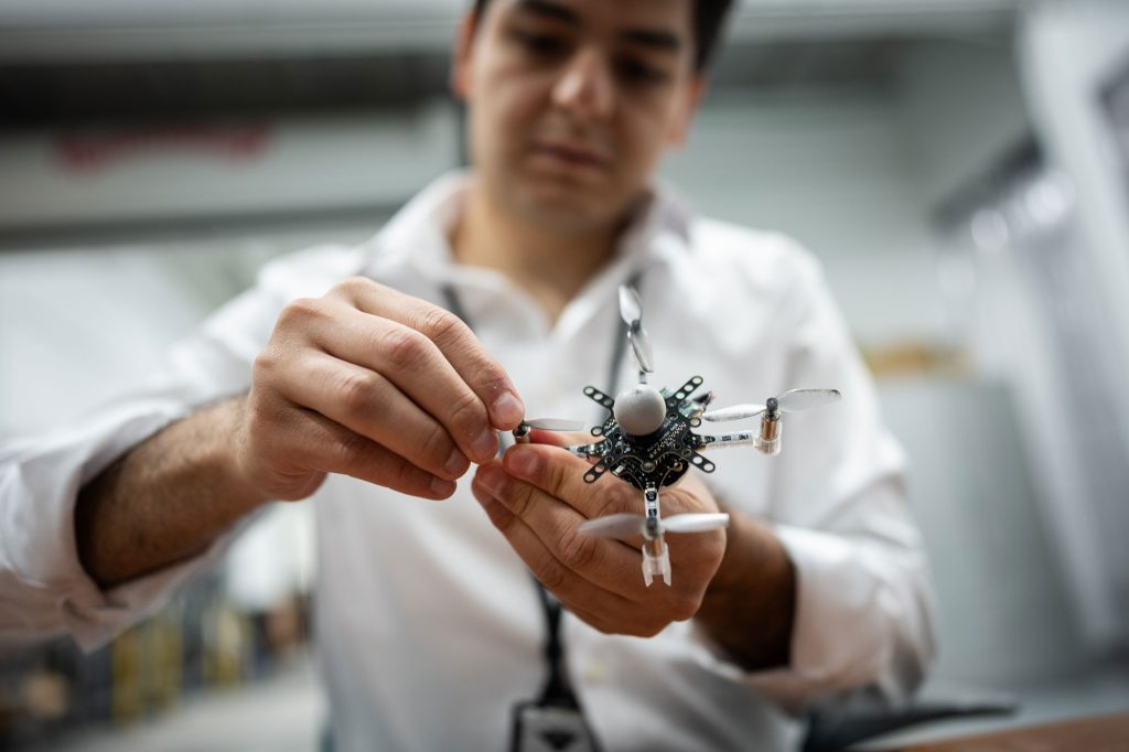 <strong>QUICK REPAIR</strong> — Sandia engineer Luis Manuel Pimentel quickly replaces a propeller on a drone. The ball on top of the drone is used by the motion capture system to pinpoint its location.
