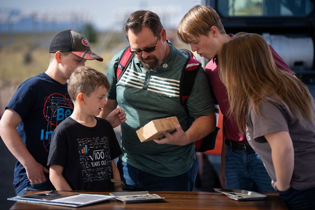 <strong>FAMILY FOCUSED</strong> — Sandia Labs’ Kids Day draws onlookers from Sandia families and the local community. Nathan, Timothy, Steve, Joshua and Elliana Dauphin, left to right, examine a ceramic firebrick that was partially melted by the solar furnace at the National Concentrated Solar Thermal Test Facility.