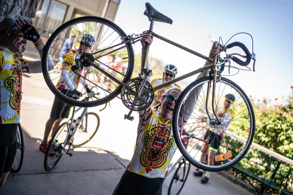 <strong>CHEERS</strong> — Sandian Laura Beidermann lifts a Penultimates teammate's bike during a 55-mile training ride. The Penultimates team, comprised of more than 50% Sandians, provides a valued work-life balance for its members.