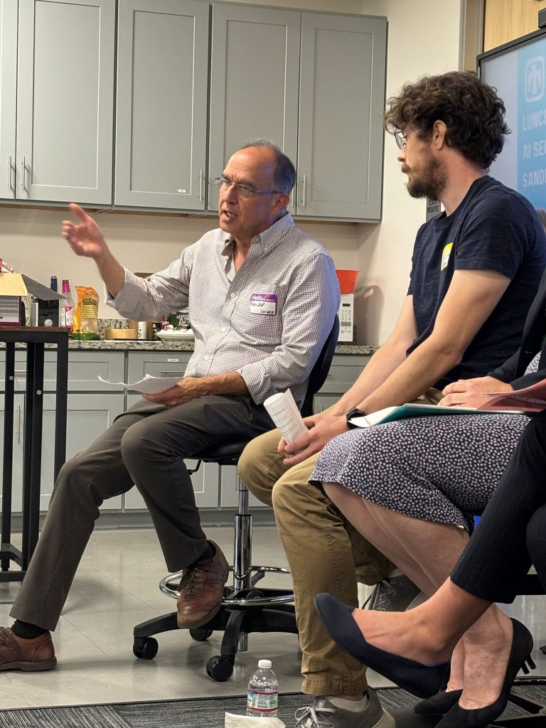 <strong>AI PANEL </strong>— Jonathan Crussell, right, listens as Philip Kegelmeyer discusses his research in counteradversarial data analytics. (Photo by Lisa O’Hara)