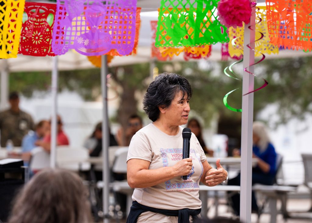 <strong>¡HOLA! </strong>— Hispanic Outreach for Leadership and Awareness Executive Champion Rita Gonzales addressed attendees at the Sept. 24 kickoff event at the auditorium, which featured the annual car show, food trucks, submissions to the Youth STEM Art Contest, and music from the Sandia Singers and DJ Matt Martinez. The Thunderbird Café also offered lunch for preorder and prepared a special dish in the cafeteria each week of Hispanic Heritage Month.
